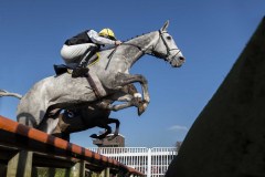 RIZZARDO AND MR ZAK BAKER LEAD JUMPING THE OPEN DITCH IN FRONT OF STANDS ON WAY TO WINNING THE NOVICE HCAP CHASE.HUNTINDON 6-2-20.Photo © George Selwyn +44 (0)7967 030722116 Wellington Parade Kent UK CT14 8AF.